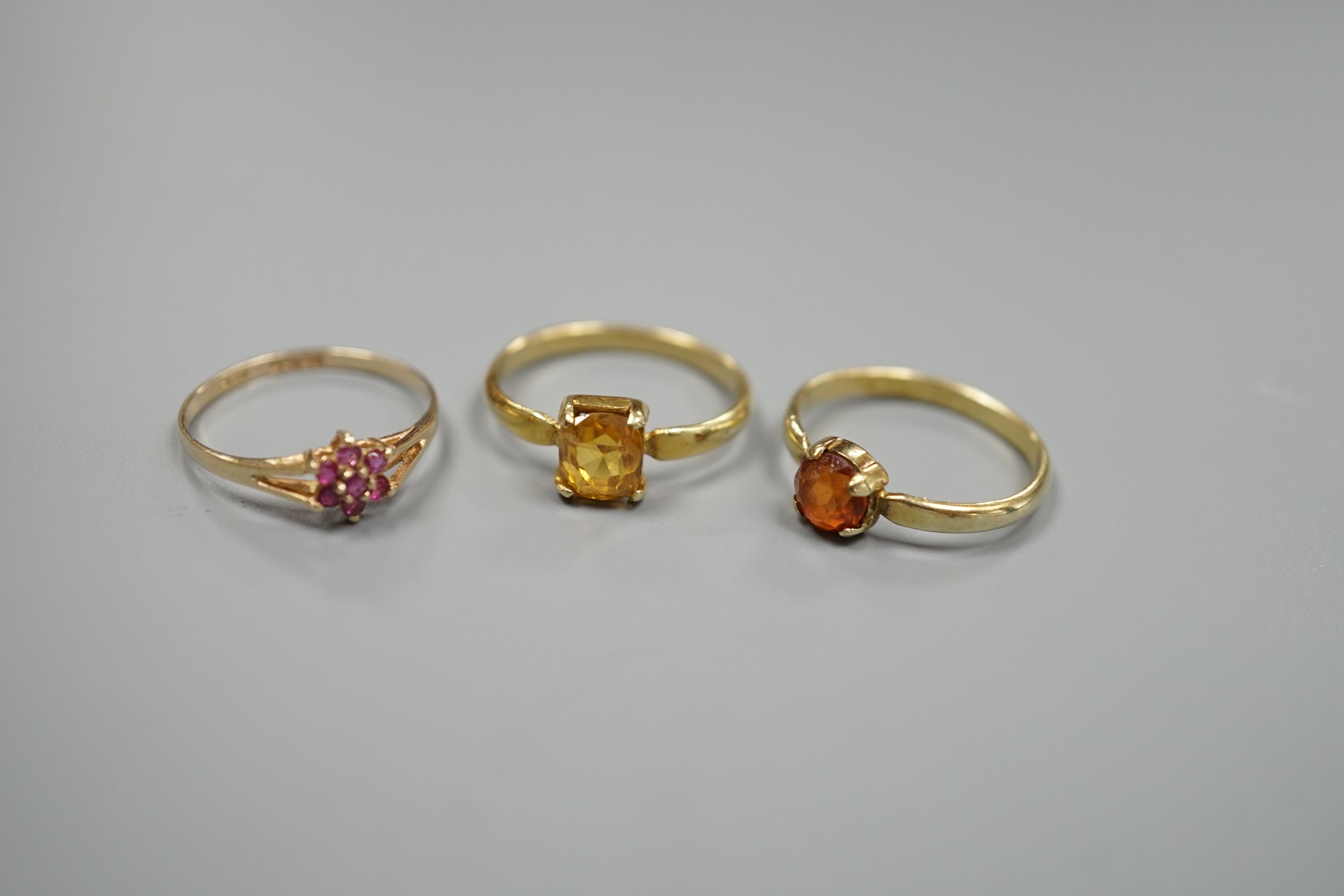 Two yellow metal and gem set rings, including garnet and citrine and a 9ct gold and gem set cluster ring, gross 5.5 grams.